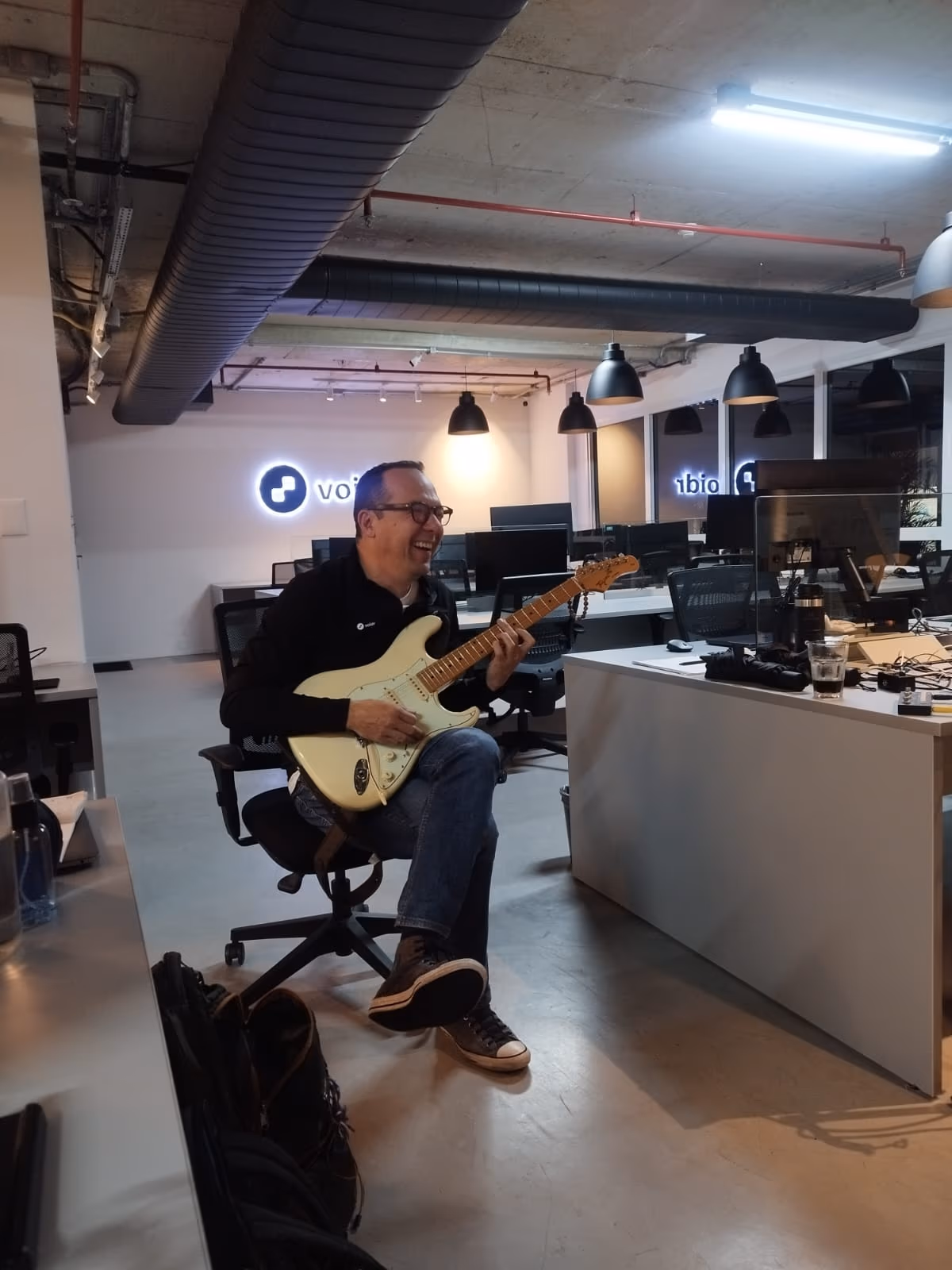 A person playing guitar at the Voidr office.